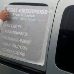 Vehicle signs being applied to the side of the van