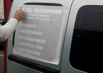 Vehicle signs being applied to the side of the van