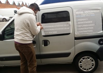 Vehicle signs being applied to the side of the van