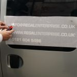 Vehicle signs being applied to the side of the van