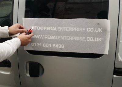 Vehicle signs being applied to the side of the van