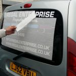Backing tape being removed from van windows